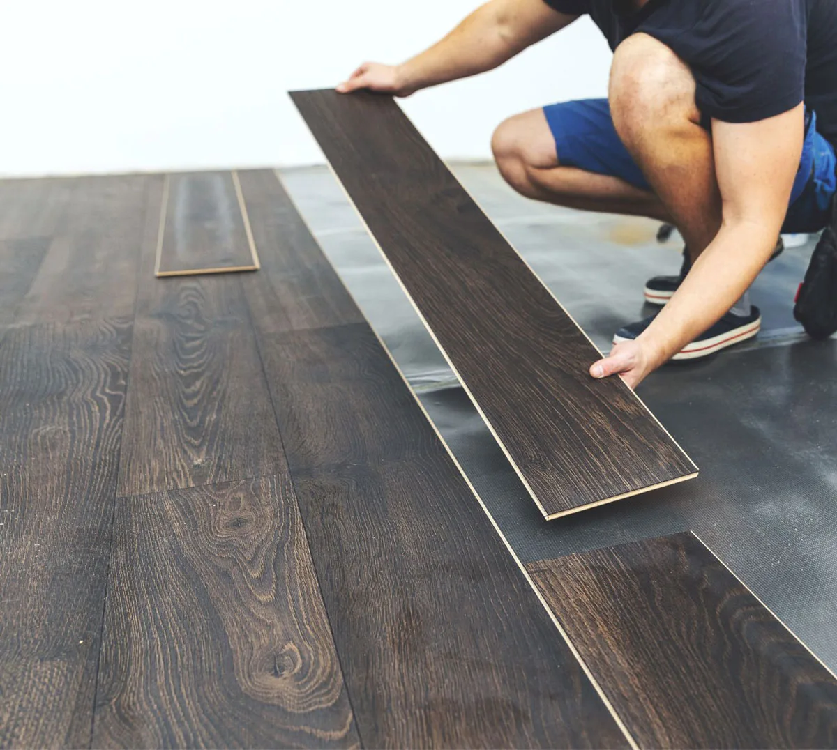 Installer placing dark wood-look luxury vinyl plank flooring in a Mokena, IL home. COREtec-style waterproof flooring ideal for kitchens, living rooms, and high-traffic areas — installed by The Floor 4U.