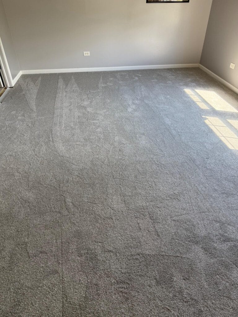 Floor 4U technician installing DreamWeaver Palmetto carpet in a Manhattan IL home bedroom using premium 8 lb padding.