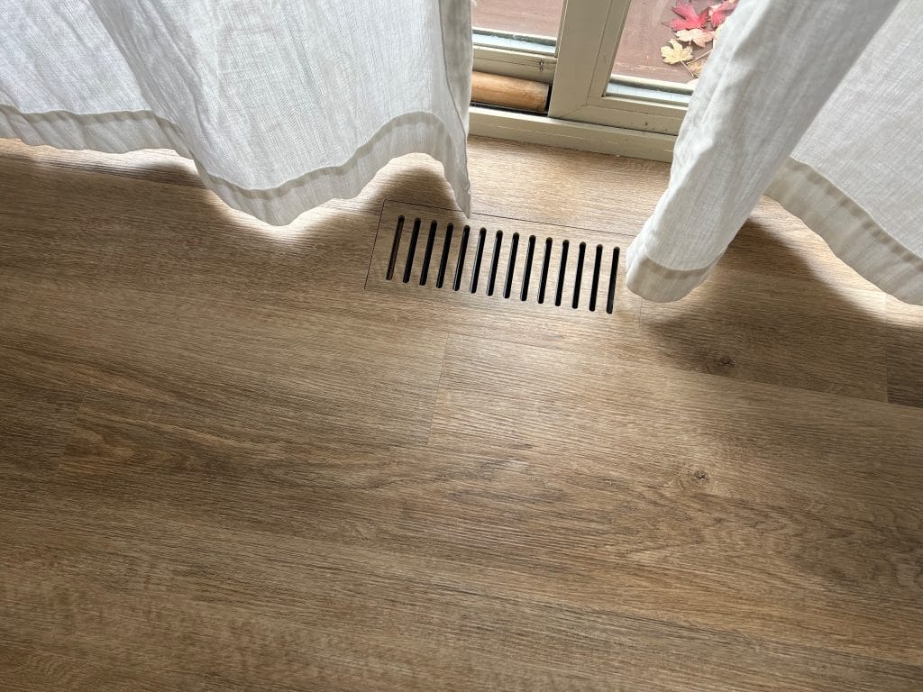 Flush mount floor vent in luxury vinyl plank flooring installed by The Floor 4 U in Homer Glen, IL. Flush Vents Mokena IL