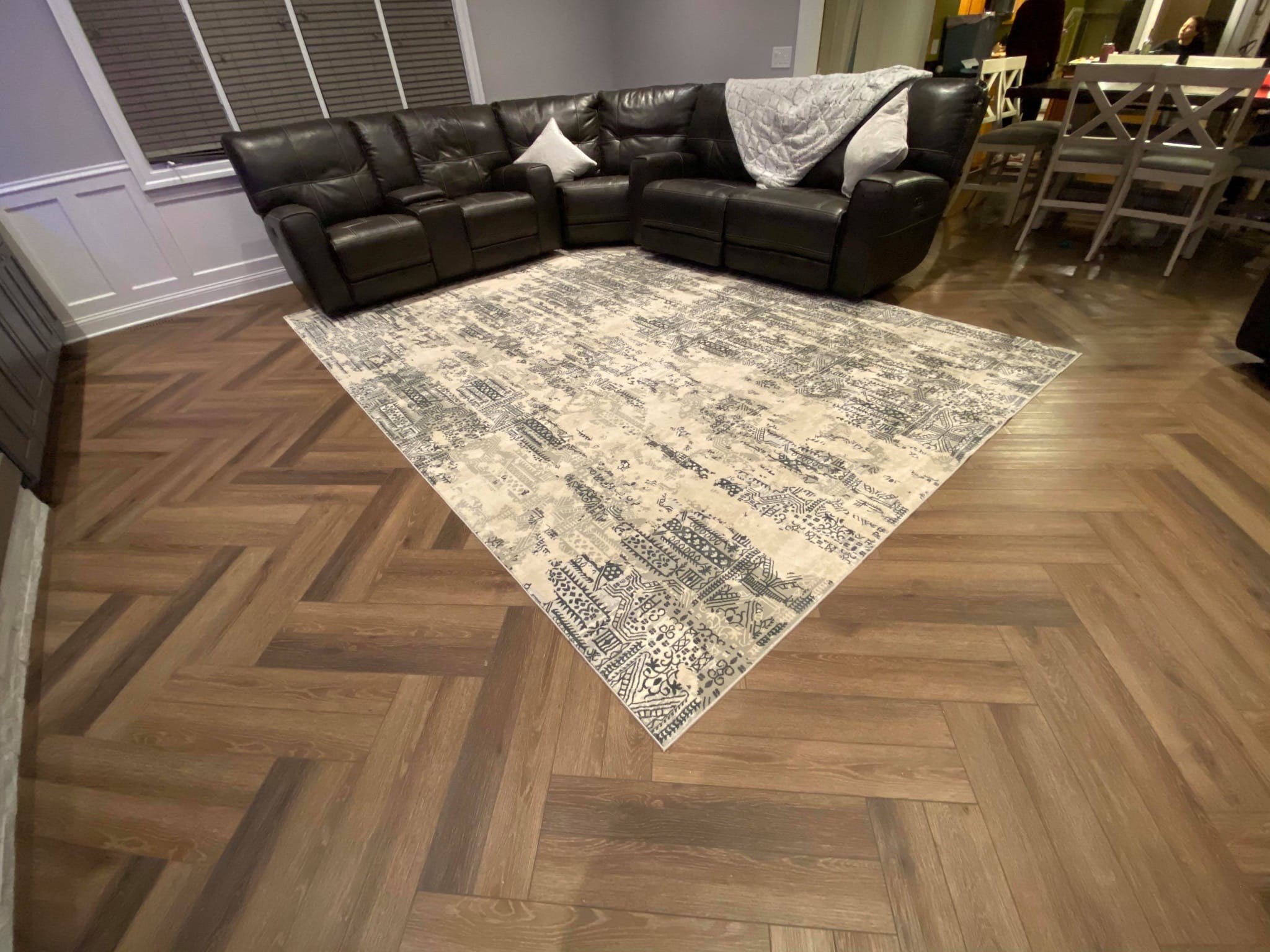 Luxury vinyl plank flooring in a herringbone pattern installed in a Tinley Park living room under a modern area rug.