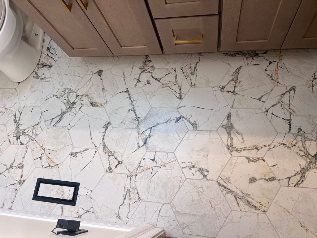 Hexagon marble-look tile bathroom flooring with natural veining in Orland Hills, IL