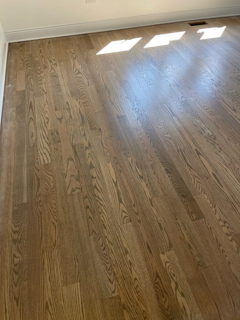 Refinished oak hardwood flooring in a New Lenox, IL home with natural light highlighting the grain.
