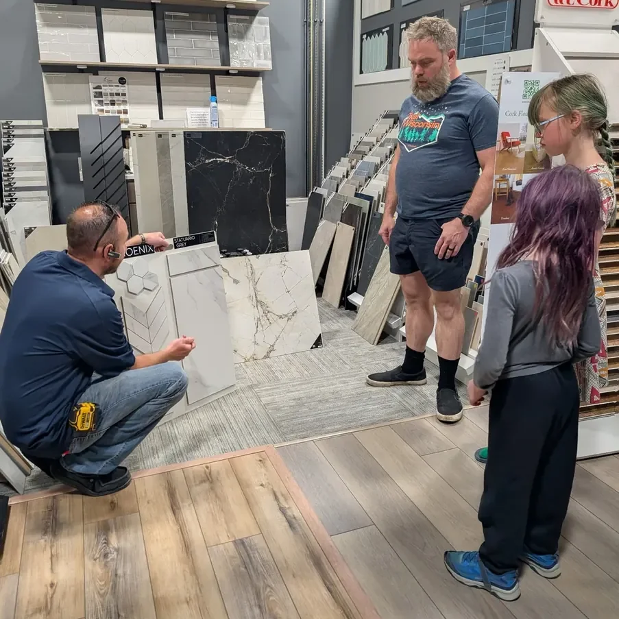 The Floor 4U team member helping a family compare tile and flooring samples in the Mokena showroom